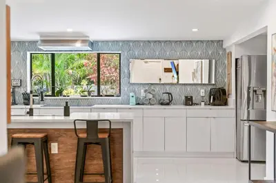 a kitchen with white cabinets and a window at Oasis with Pool & Cold Plunge-Near Beach & Nightlife in Fort Lauderdale