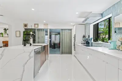 a kitchen with white counters and a large window at Oasis with Pool & Cold Plunge-Near Beach & Nightlife in Fort Lauderdale
