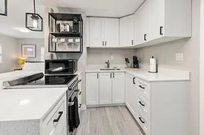 a kitchen with white cabinets and a stove top oven at Perfect stay for 2-Walk to Wilton Drive-Shops &bars in Fort Lauderdale