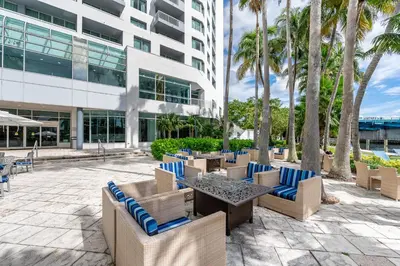 a patio with chairs and tables in front of a building at Amazing Intracoastal Views - Walk to the Beach! in Fort Lauderdale