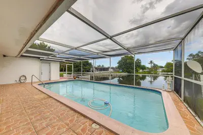 an indoor swimming pool with a large window at Canal-Front Gem with Pool 3 Mi to Hard Rock Stadium in Miramar