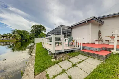 a house with a dock next to a river at Canal-Front Gem with Pool 3 Mi to Hard Rock Stadium in Miramar