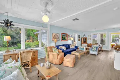 a living room with a blue couch and chairs at Bromeliad Bungalow - Downtown Cottage in Fort Lauderdale