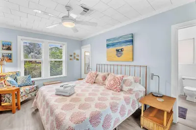 a bedroom with a bed and a bathroom at Bromeliad Bungalow - Downtown Cottage in Fort Lauderdale