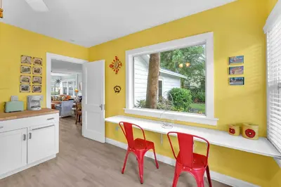 a kitchen with two red chairs and a window at Bromeliad Bungalow - Downtown Cottage in Fort Lauderdale