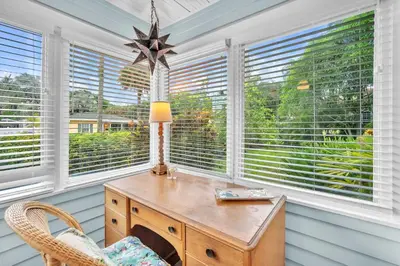 a home office with a wooden desk and windows at Bromeliad Bungalow - Downtown Cottage in Fort Lauderdale