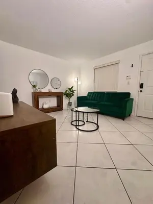 a living room with a green couch and a table at Beautiful 2brm condo w free parking fast WiFi in Lindgren Acres