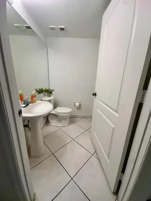 a white bathroom with a toilet and a sink at Beautiful 2brm condo w free parking fast WiFi in Lindgren Acres