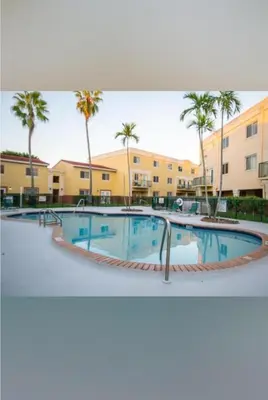 a pool at a resort with palm trees and buildings at Beautiful 2brm condo w free parking fast WiFi in Lindgren Acres