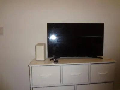 a flat screen tv sitting on top of a dresser at Miami Fort Lauderdale Vacation Rooms in Miramar