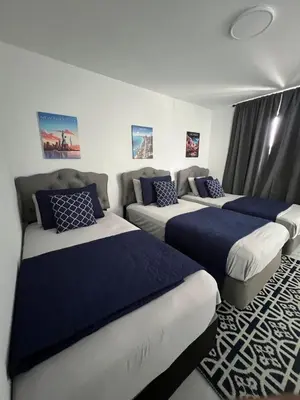 a room with three beds and a couch at Magic City IN THE HEART OF MIAMI in Miami