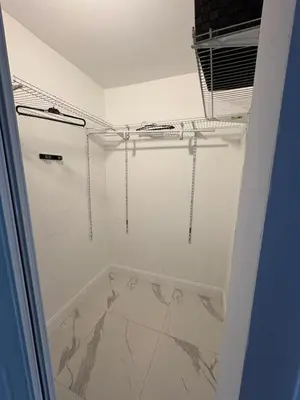 a bathroom with white walls and a marble floor at Family Willy Michel in Opa-locka
