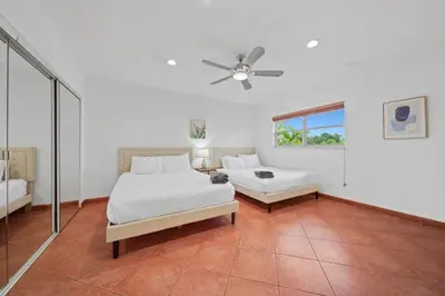 a bedroom with two beds and a ceiling fan at Luxe Escape 2BR Fort Lauderdale in Fort Lauderdale
