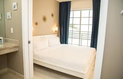 a small bedroom with a bed and a window at Spacious Studio Rooftop Pool & Bar with Ocean View in Miami Beach