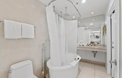 a bathroom with a toilet and a shower and a sink at Spacious Studio Rooftop Pool & Bar with Ocean View in Miami Beach