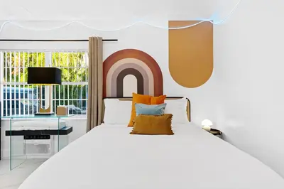 a bedroom with a large white bed with orange pillows at Cozy 4BR Pool Villa Near The Beach with Arcades in Fort Lauderdale