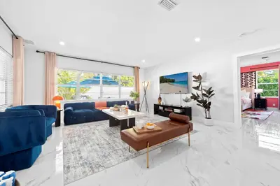 a living room with a blue couch and a table at Cozy 4BR Pool Villa Near The Beach with Arcades in Fort Lauderdale