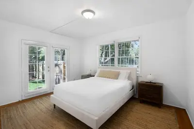 a white bedroom with a bed and two windows at Memory Lane Cozy Home with Pool Lush South Miami in Miami