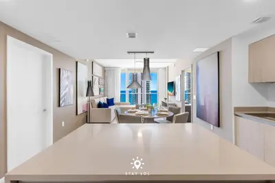 a kitchen and living room with a large white table at Luxury 2BR Apt With Ocean View Pool & Amenities in Hollywood