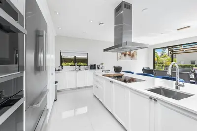 a white kitchen with white cabinets and a sink at Villa Costa in Hollywood