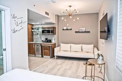 a living room with a couch and a kitchen at Cozy Studio Ocean Drive - Roof Top Pool with Bar in Miami Beach