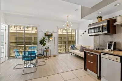 a kitchen and living room with a table and chairs at Miami Ocean Drive 1BR APT & Rooftop Pool Access in Miami Beach