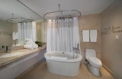a bathroom with a tub and a toilet and a sink at The iconic Ocean Drive - 1 BDR - Rooftop Pool and Bar in Miami Beach