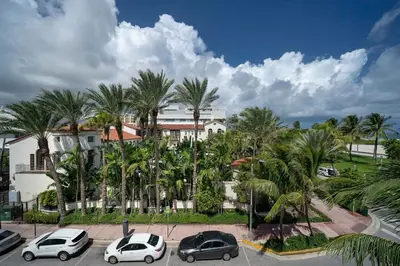 a group of cars parked in a parking lot with palm trees at The iconic Ocean Drive - 1 BDR - Rooftop Pool and Bar in Miami Beach