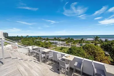 a balcony with chairs and a view of the ocean at Ocean Dr 1BR Apt with Rooftop Pool 93 Walk Score in Miami Beach