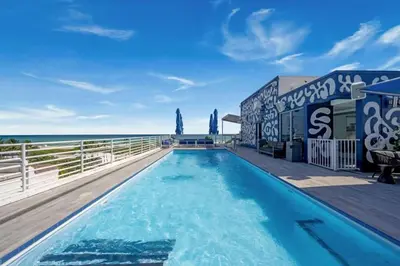 a swimming pool with the ocean in the background at Ocean Dr 1BR Apt with Rooftop Pool 93 Walk Score in Miami Beach
