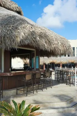 a bar with chairs and a straw roof at Lovely 2-Bedroom Oceanfront condo in Sunny Isles Beach