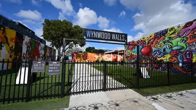 a gate with a fence with graffiti on it at Cozy 1BR Apt Steps from Calle 8 & Mins to Brickell in Miami