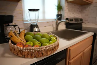a basket of fruit on a counter next to a sink at Near Brickell, Beach & Port 10min, Style & Comfort in Miami