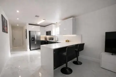 a white kitchen with a counter and a refrigerator at Villa Miami Lakes 2 in Hialeah