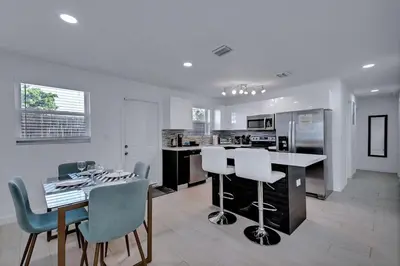 a kitchen and dining room with a table and chairs at Modern 2BR Near Wynwood and Design District in Miami