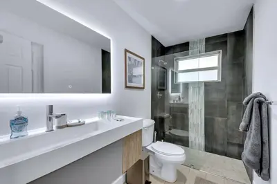 a white bathroom with a sink and a toilet at Modern 2BR Near Wynwood and Design District in Miami