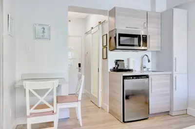 a small kitchen with a counter and a microwave at Sunny Beach Studio Steps to Ocean and Nightlife in Miami Beach