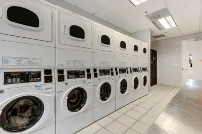 a row of white washing machines in a laundry room at Newly Renovated Brickell Stay with Views and Amenities in Miami