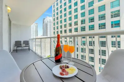 a table with a bottle of wine and glasses on a balcony at Newly Renovated Brickell Stay with Views and Amenities in Miami