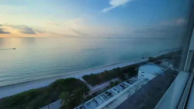 a view of the beach and the ocean at sunset at Amazing ocean view studio 14 floor Free parking in Miami Beach