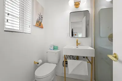 a bathroom with a toilet and a sink and a mirror at The Bianco in Miami