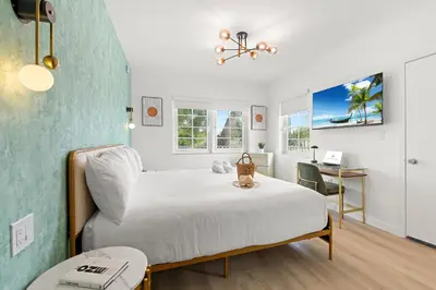 a bedroom with a white bed and a desk at The Bianco in Miami