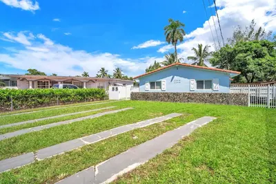 a yard with a white fence and a house at Costerra Miami 2BR in Miami