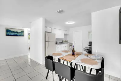 a kitchen with a table with a bottle of wine at Costerra Miami 2BR in Miami