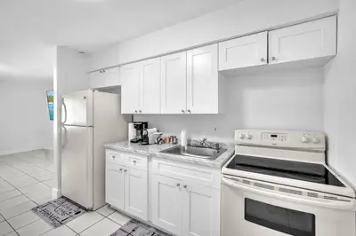 a white kitchen with a sink and a refrigerator at Costerra Miami 2BR in Miami