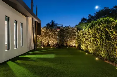 a garden with artificial grass and lights on the side of a building at Villa Coral Wave in Miami