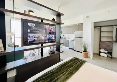 a living room with a large television and a kitchen at SPECIAL OFFER - Luxury High Rise Downtown Miami - Bay Views and Top Amenities in Miami