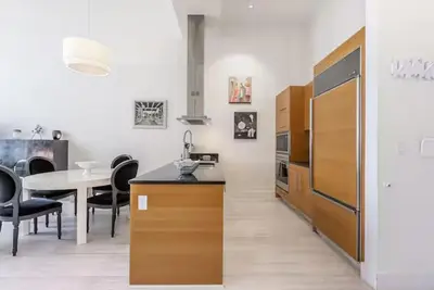 a kitchen and dining room with a table and a refrigerator at Beautiful Icon Brickell Double height ceiling in Miami