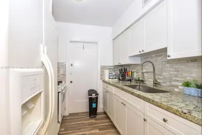 a white kitchen with a sink and a counter at North Beach-Room with Private Entrance in Miami Beach