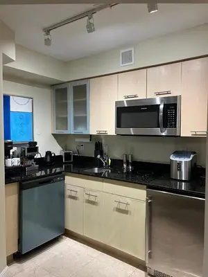 a kitchen with stainless steel appliances and a microwave at Luxury Waterfront Condo Hilton Hotel Amenities Beach Pool Jacuzzi Jetskis Gym in Fort Lauderdale